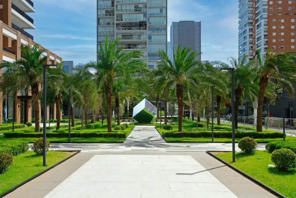 Eixo central da praça do Praça Lindenberg Itaim, com palmeiras e paisagismo de Benedito Abbud. Foto real